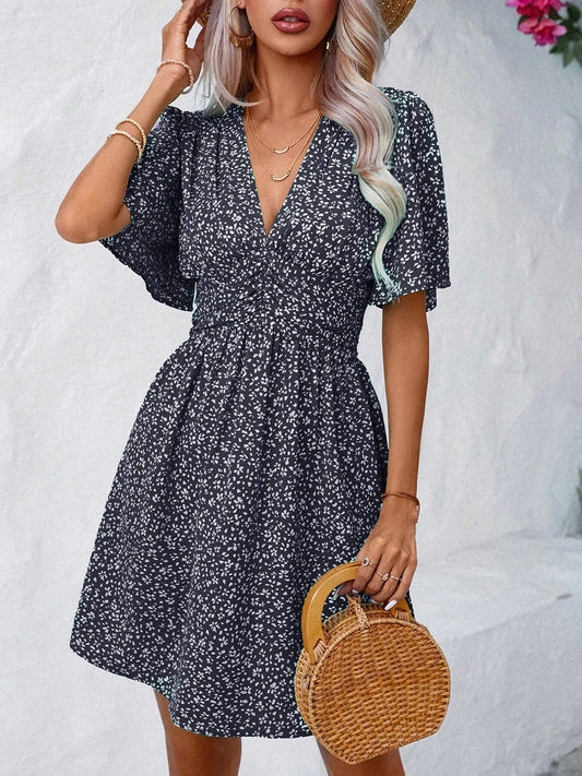Woman wearing a printed V-neck mini dress with half sleeves and holding a round wicker handbag