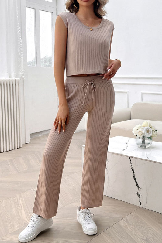 Woman wearing beige ribbed round neck top and matching pants set with tie waist and white sneakers indoors